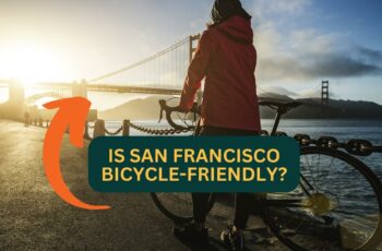 Woman with bicycle standing in front of Golden Gate Bridge in San Francisco